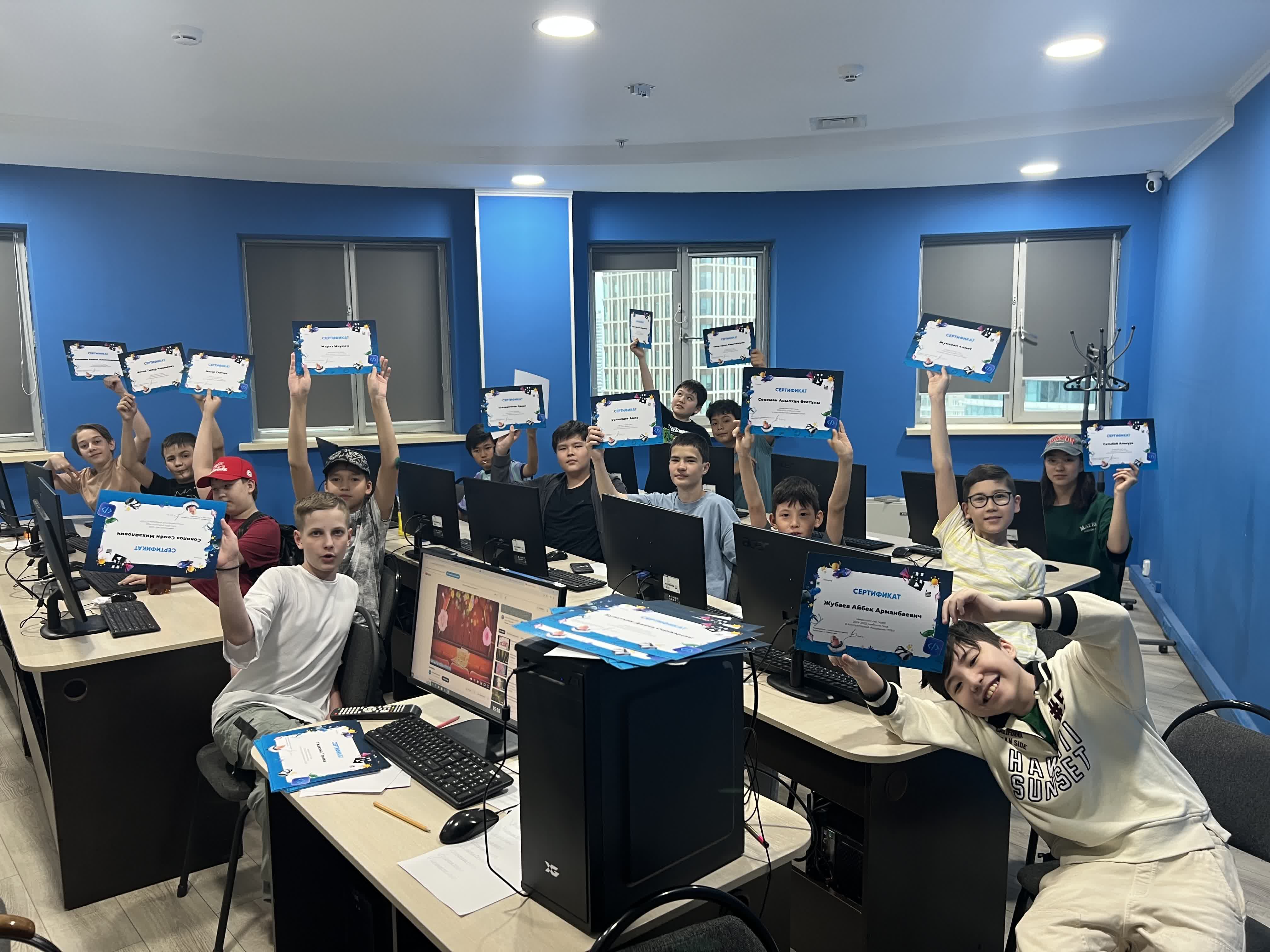 Students holding certificates in a computer lab at ITSTEP Academy
