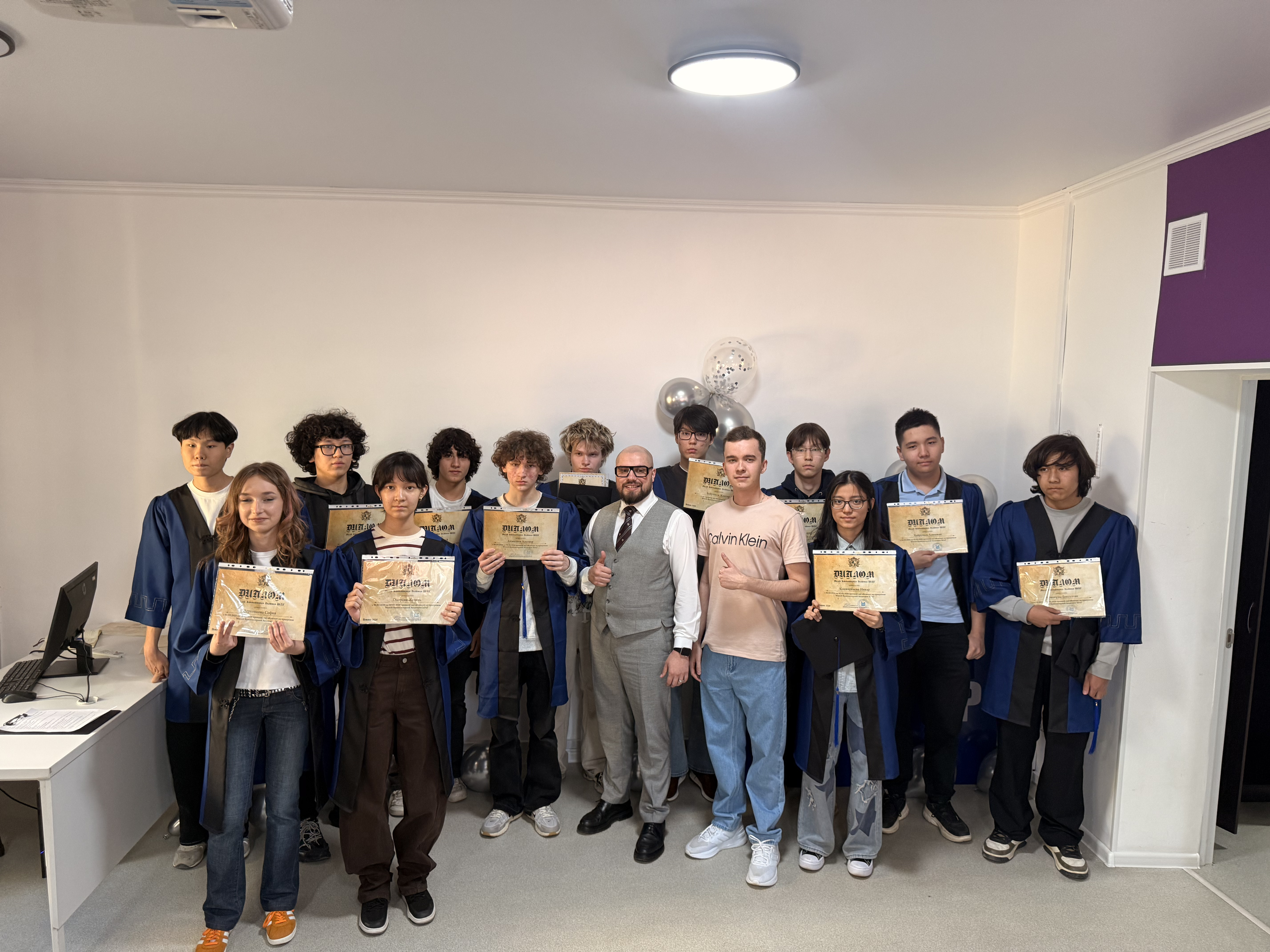 Students holding diplomas at an ITSTEP Academy graduation ceremony
