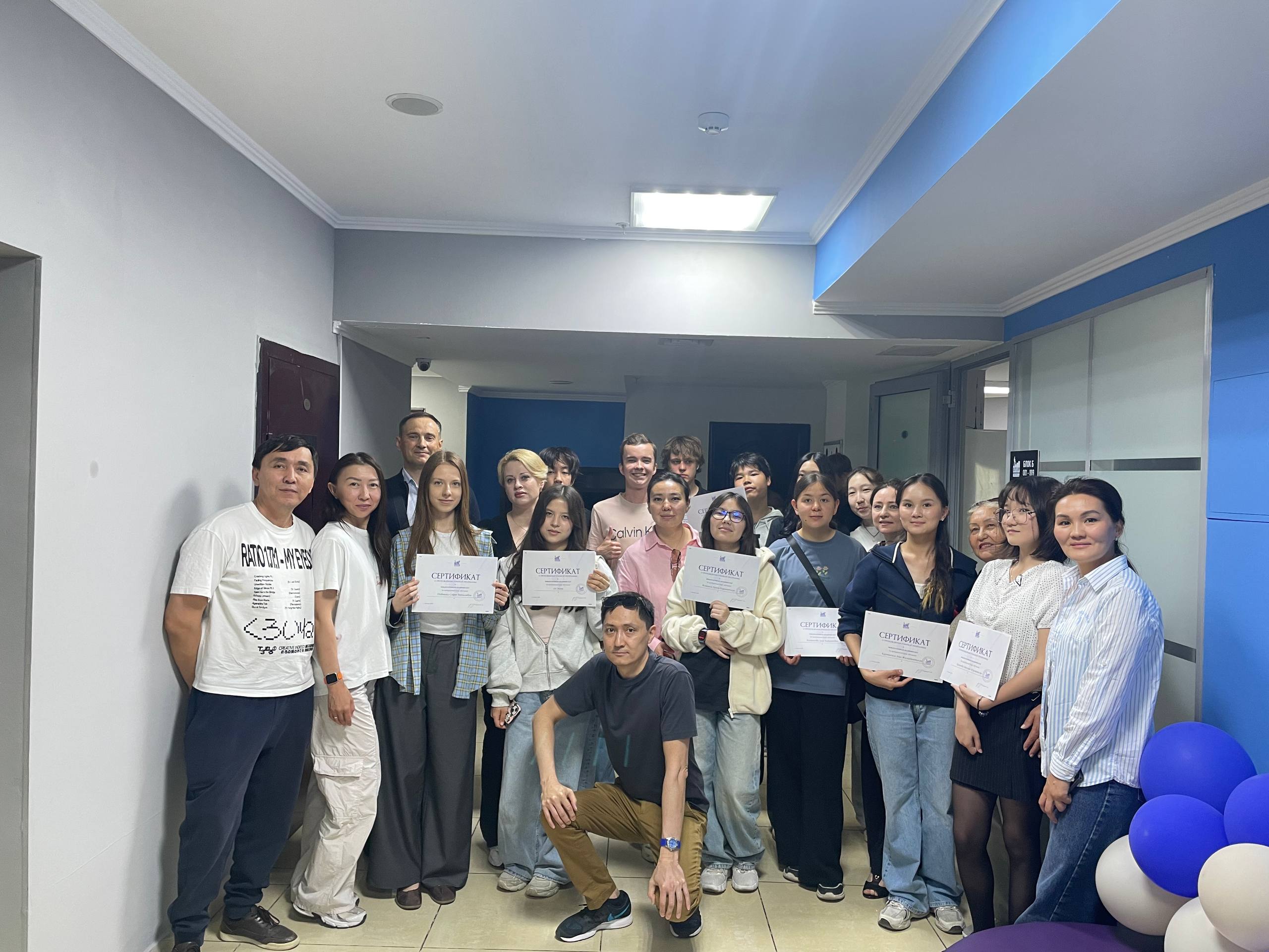 Students holding certificates in the hallway at ITSTEP Academy