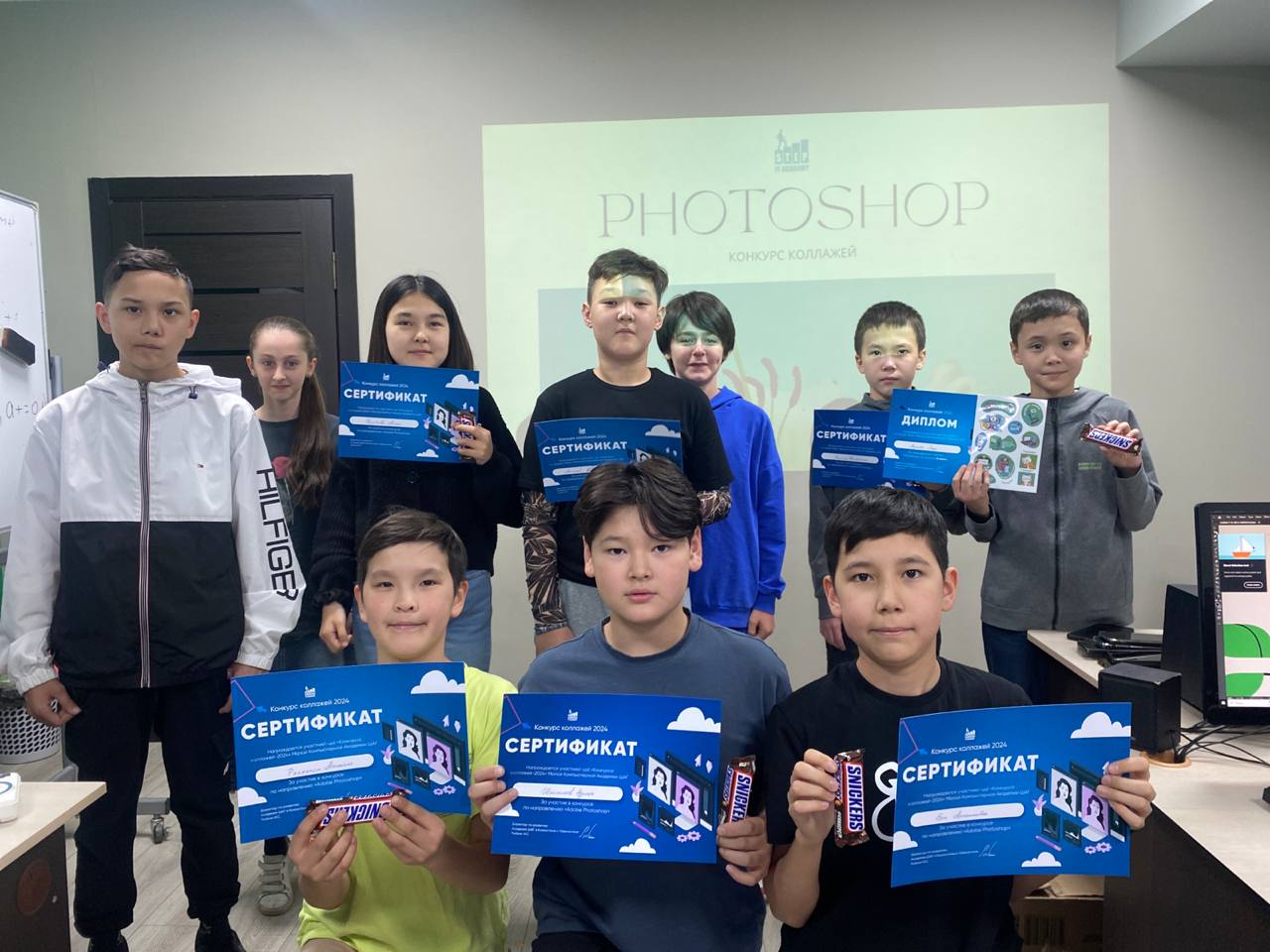Students holding certificates from a Photoshop collage contest at ITSTEP Academy
